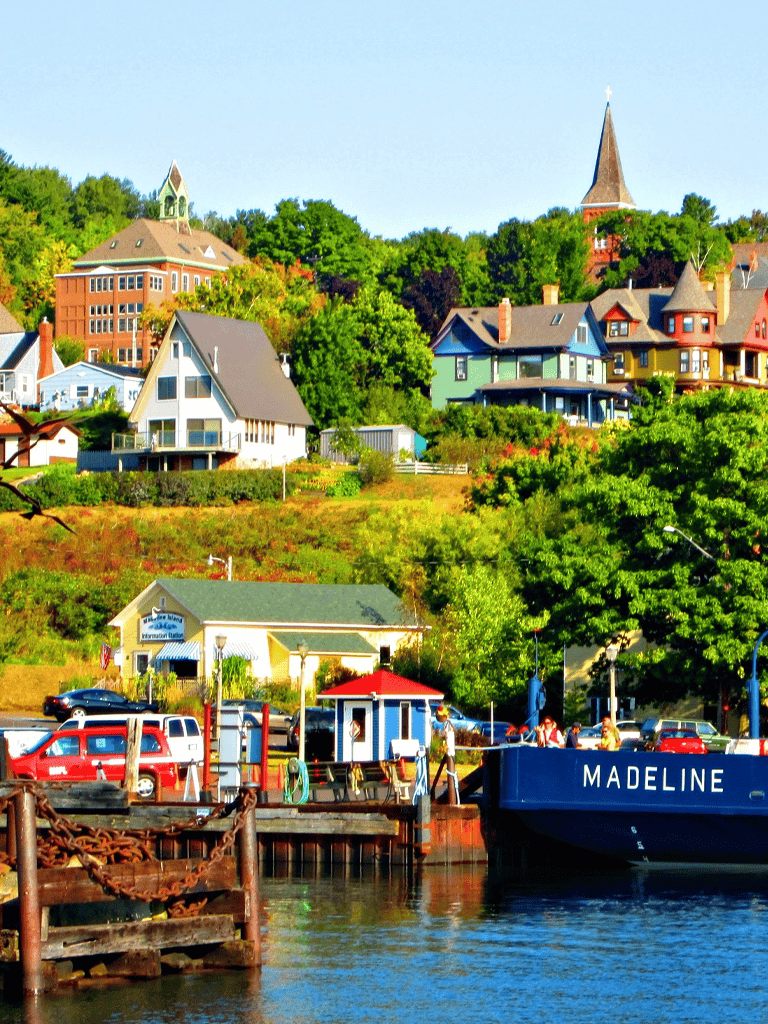 Colorful hillside houses in a scenic waterfront town, perfect for travel and navigation guidance.