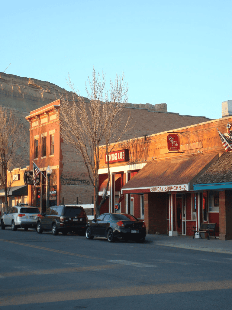 Charming downtown street in Leadville, Colorado with local cafes and shops near mountainous landscape.