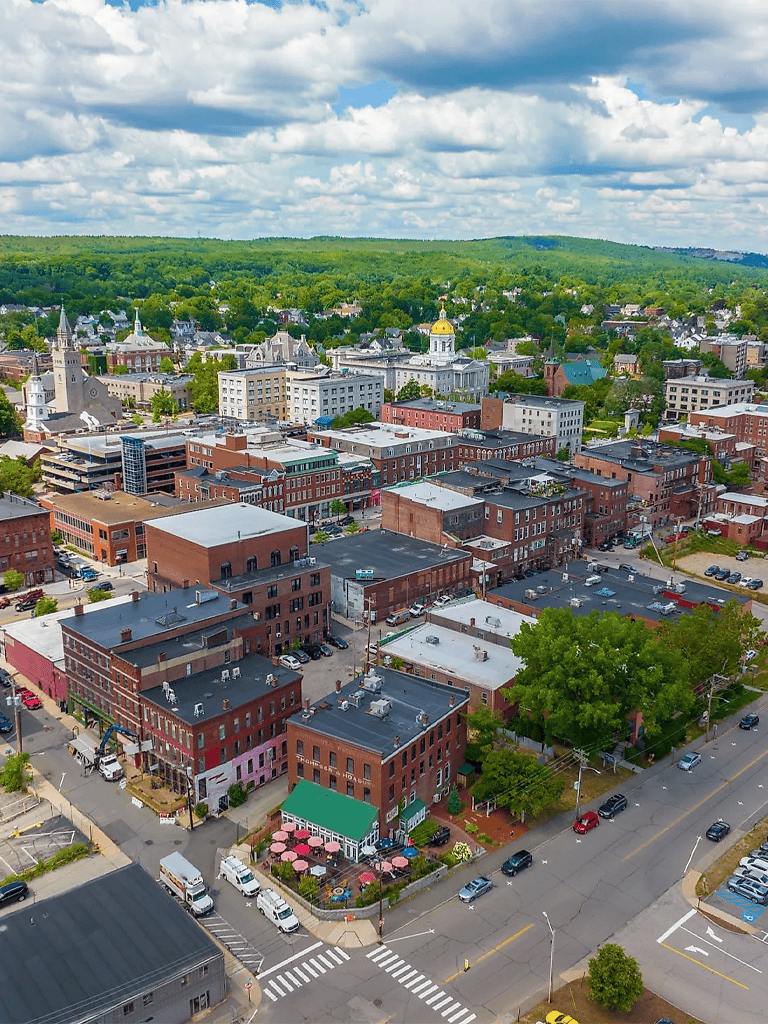 Historic downtown cityscape with vibrant shops and lush green hills, showcasing local attractions and community spirit.