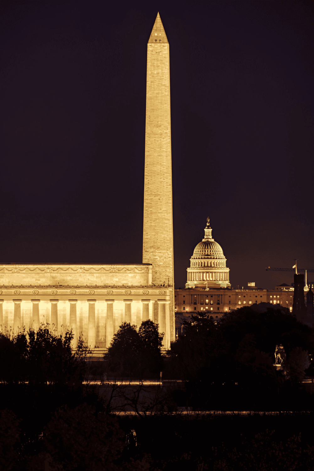 Boston night skyline with illuminated Washington Monument and Capitol building, classic American architecture.