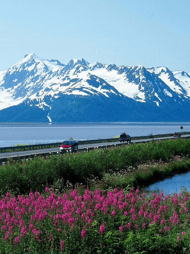 Scenic mountain view with snow-capped peaks and a highway, perfect for travel and adventure keywords.