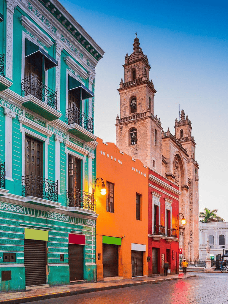 Colorful colonial buildings in Mexico City with historic church in background.