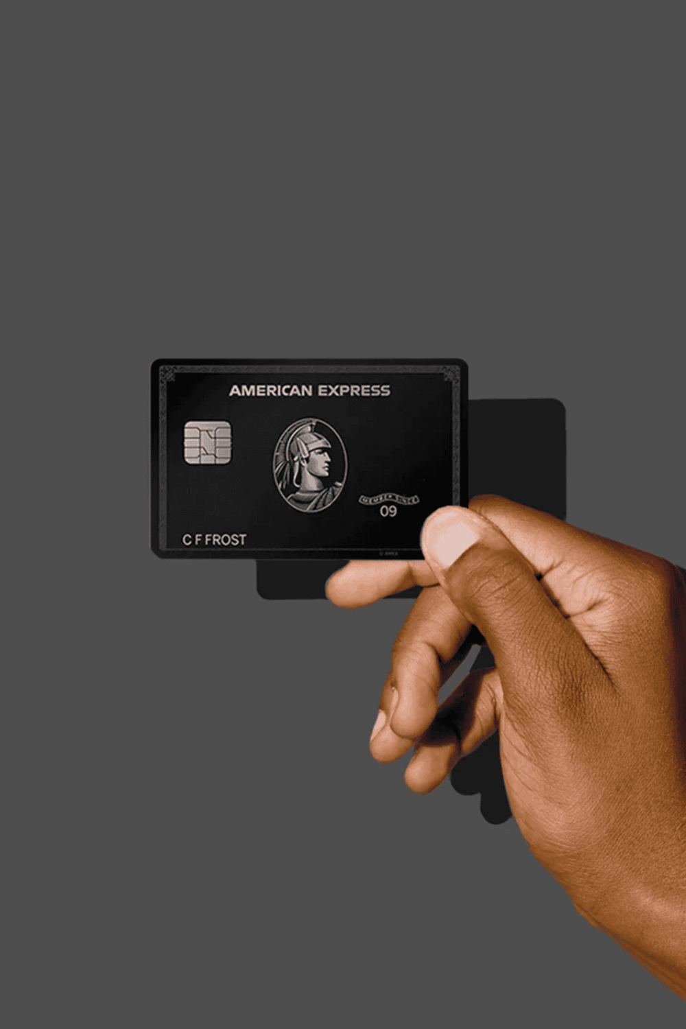 Black American Express credit card held by hand, symbolizing premium financial services and exclusive rewards.