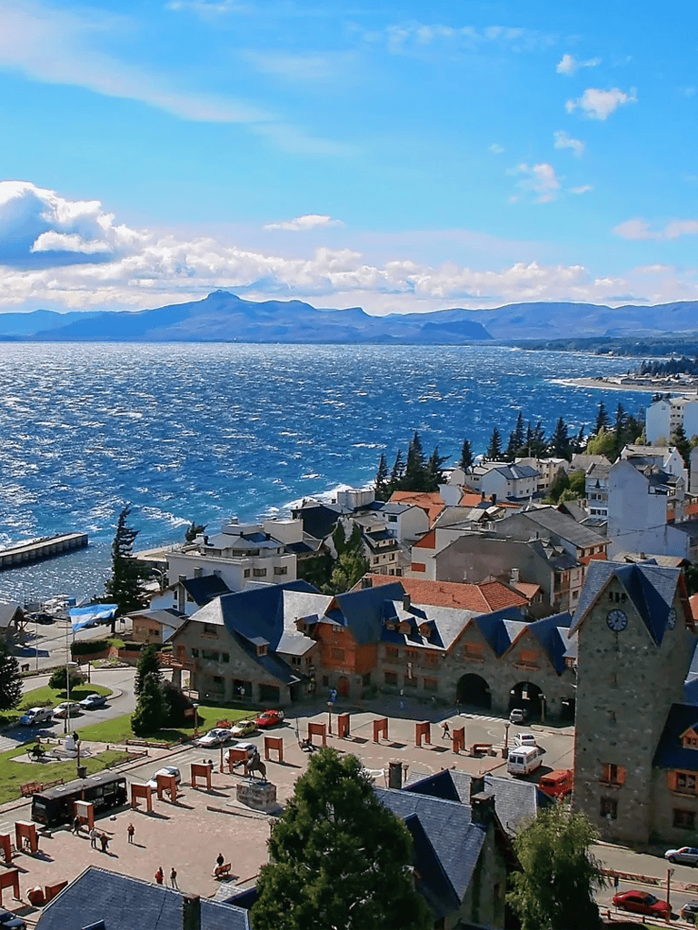 Vibrant lakeside town with colorful houses, a scenic waterfront, and mountain views, perfect for travel and exploration.