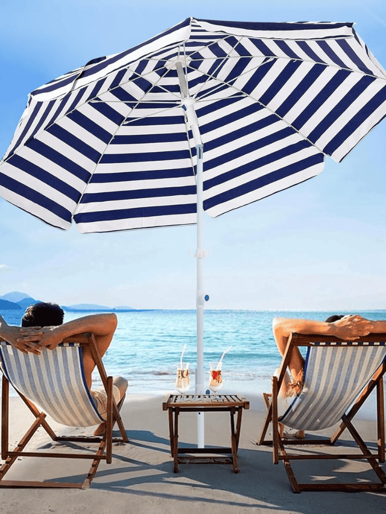 Relaxing beach scene with umbrella and people enjoying the seaside view.