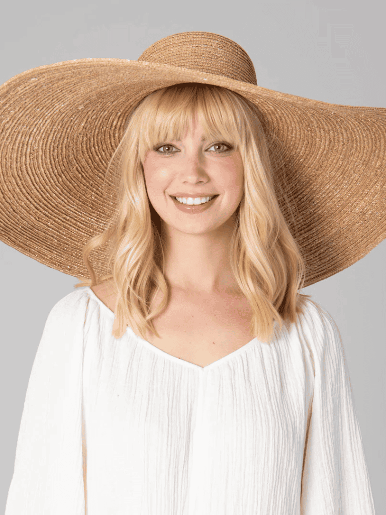 Sun hat, smiling woman wearing sun protection, summer fashion, vacation style, outdoor accessory, summer fashion essentials, woman with straw hat, beach outfit, stylish sun hat, sunny day fashion.