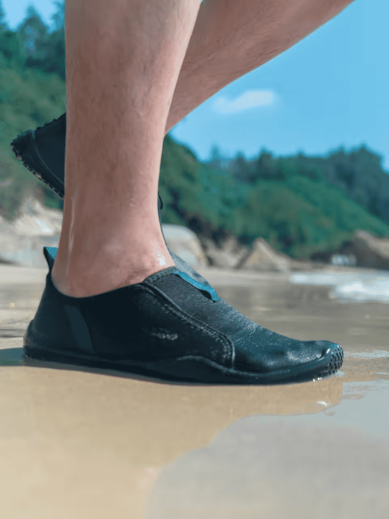 Wetsuit shoes on sandy beach, exploring nature and outdoor adventure.