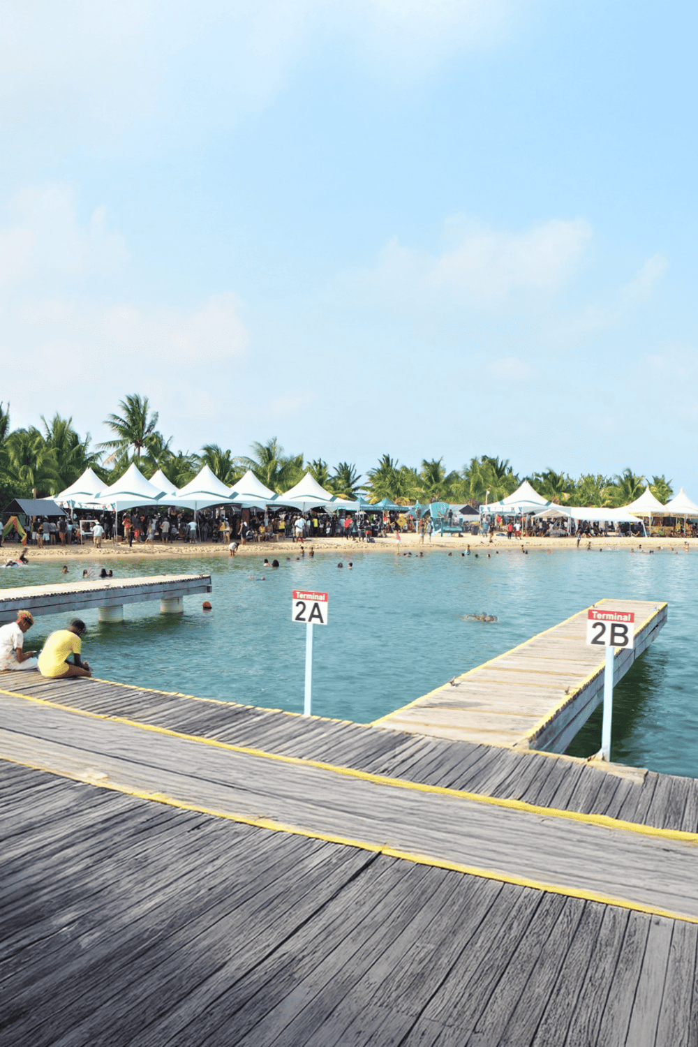 Relaxing dock scene at tropical beach with tents and visitors, adventure and travel planning in paradise, scenic destination for vacationers.