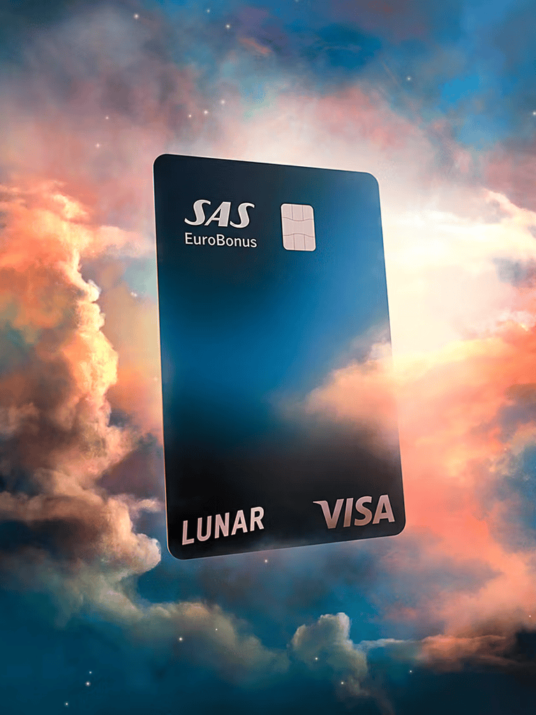 SAS EuroBonus Lunar Visa credit card floating in a cosmic sky scene with clouds and stars.
