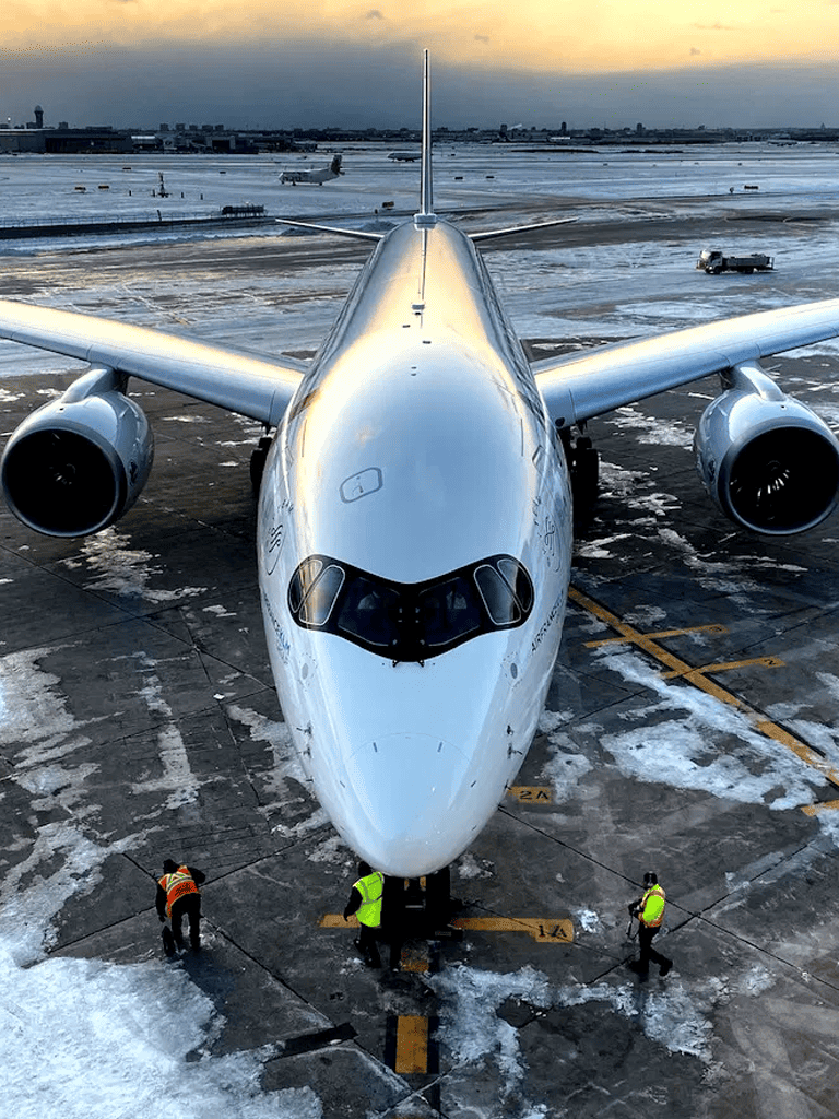Empty airport tarmac with a large commercial airplane preparing for takeoff in winter conditions.