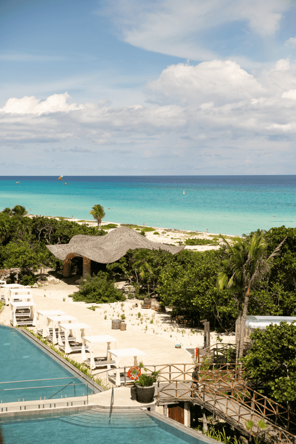 Luxury beach resort with infinity pool, tropical gardens, and ocean view for vacation relaxation.