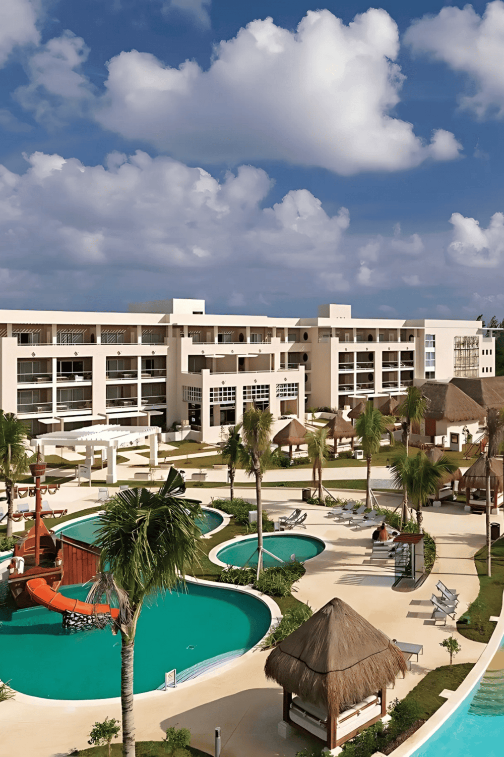 Luxurious beachfront resort with pools, palm trees, and modern hotel rooms in a tropical setting.