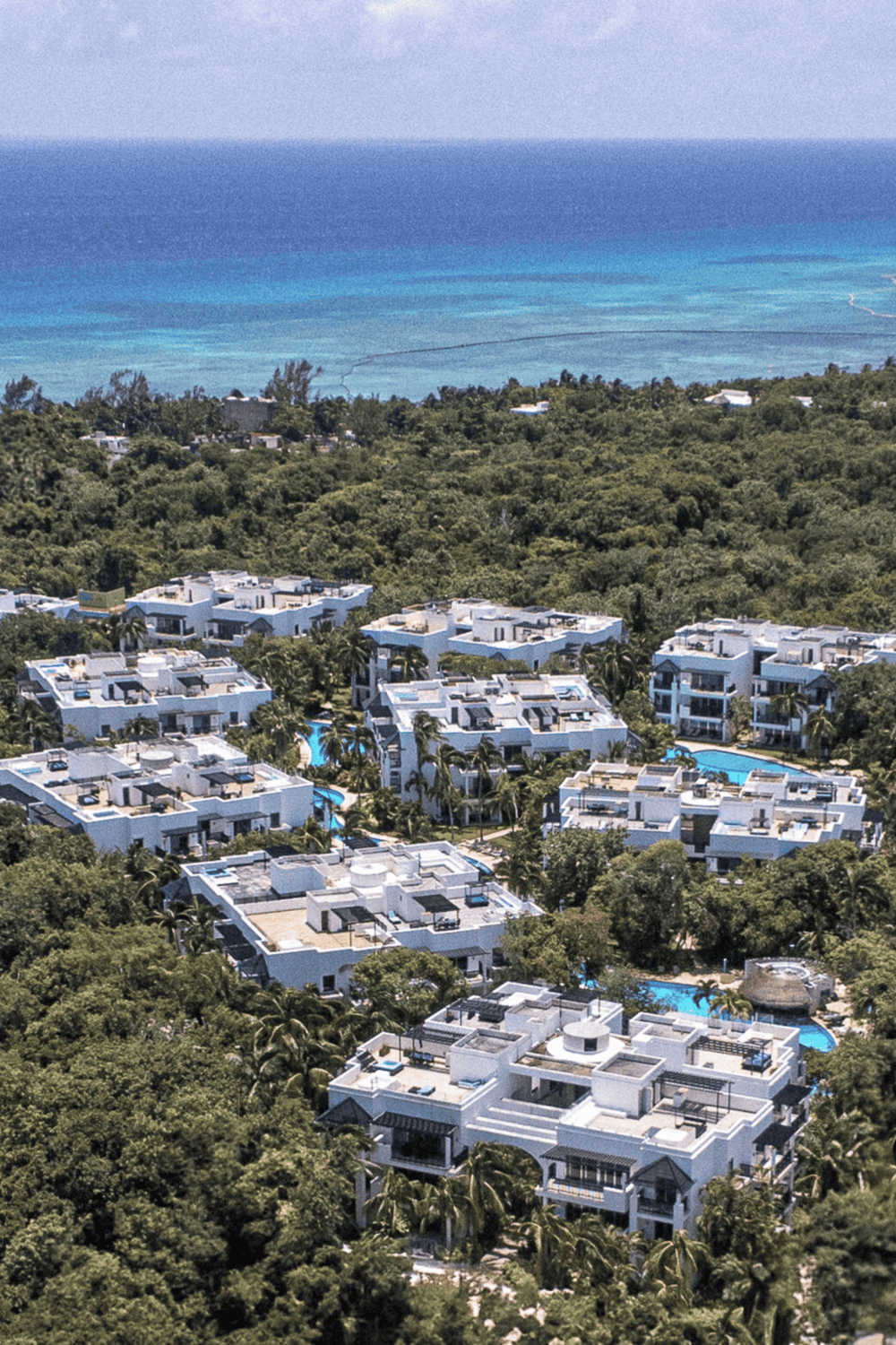 Luxurious beachside resort with swimming pools and lush greenery, offering ultimate relaxation and scenic ocean views.