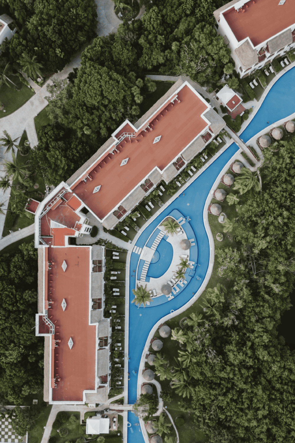 Elegant resort with swimming pools amid lush greenery, perfect for luxury vacations and relaxation.