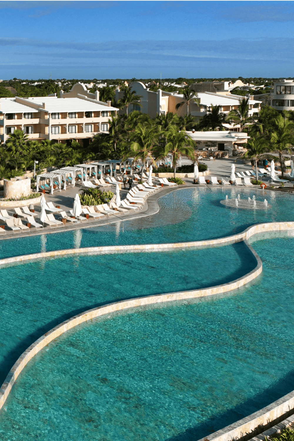 Luxurious resort swimming pool with cabanas, palm trees, and resort-style amenities.