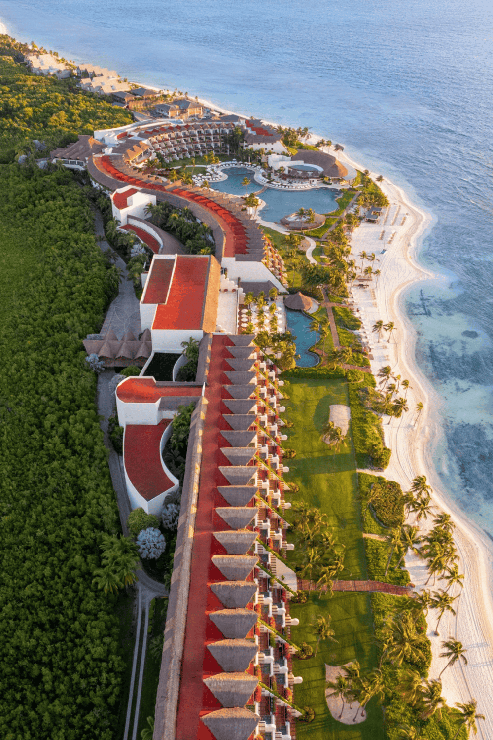Luxurious beachfront resort with pools, palm trees, and ocean view in Cancun, Mexico.
