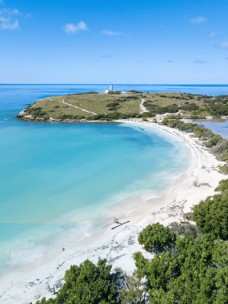 Stunning coastal view of lighthouse and sandy beach at Quest for Directions site.