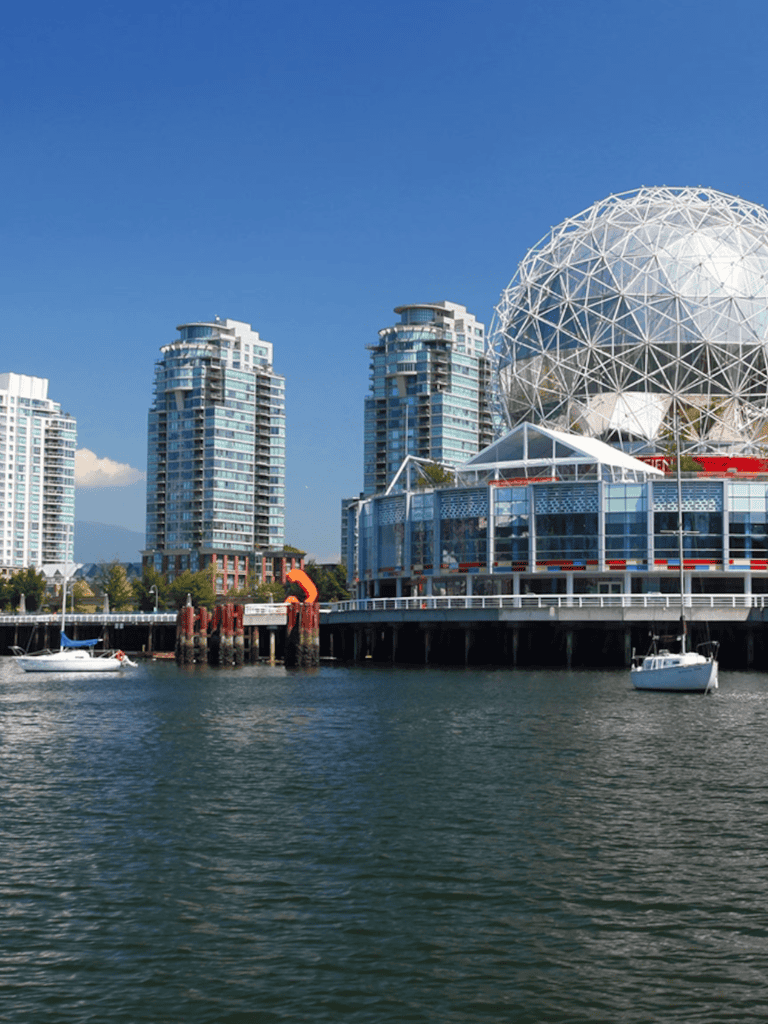 Modern Vancouver skyline with Science World geodesic dome and waterfront boats at False Creek.