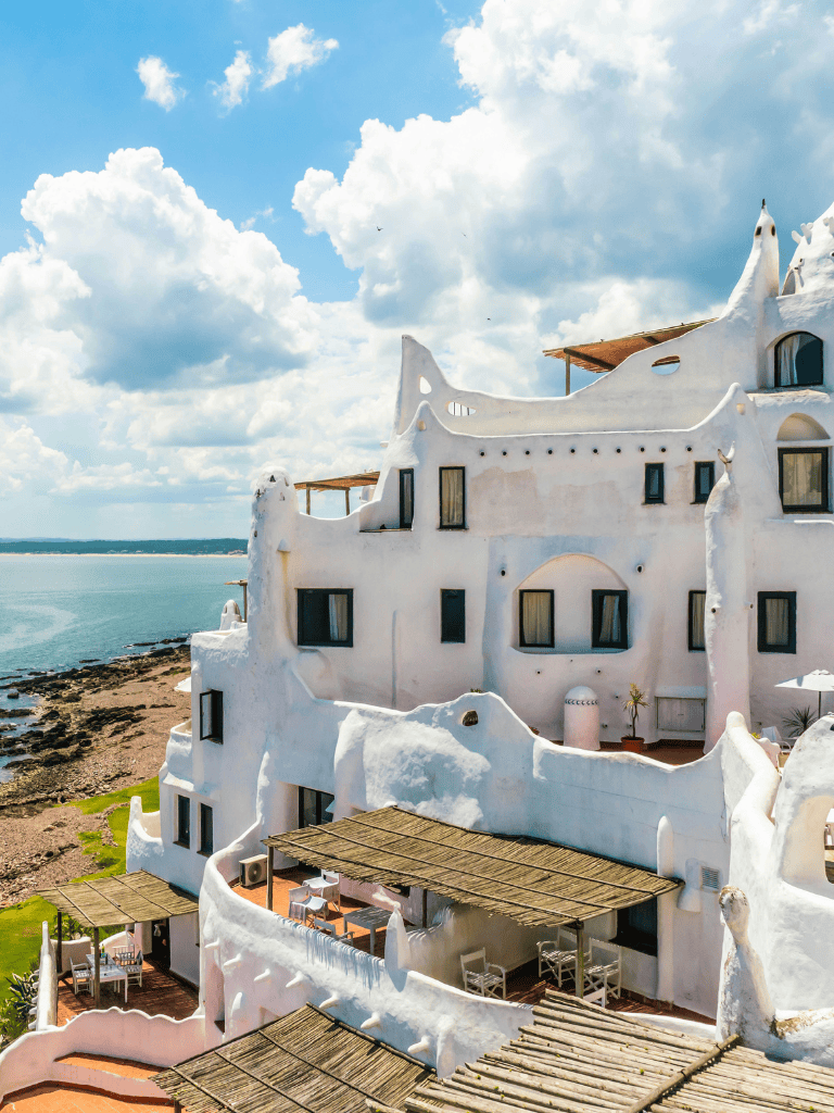 Whimsical white seaside building with unique architecture and ocean view, perfect for travel inspiration.