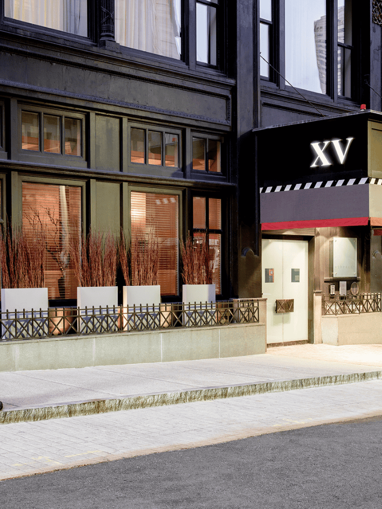 Elegant theater entrance with "XV" marquee, urban sidewalk setting, ideal for entertainment venue SEO.