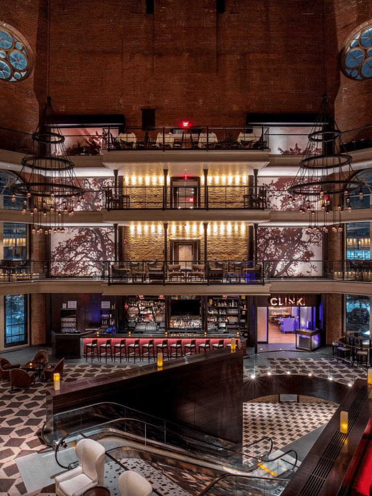 Aesthetic hotel bar with multiple floors, modern design, and ambient lighting for upscale nightlife.