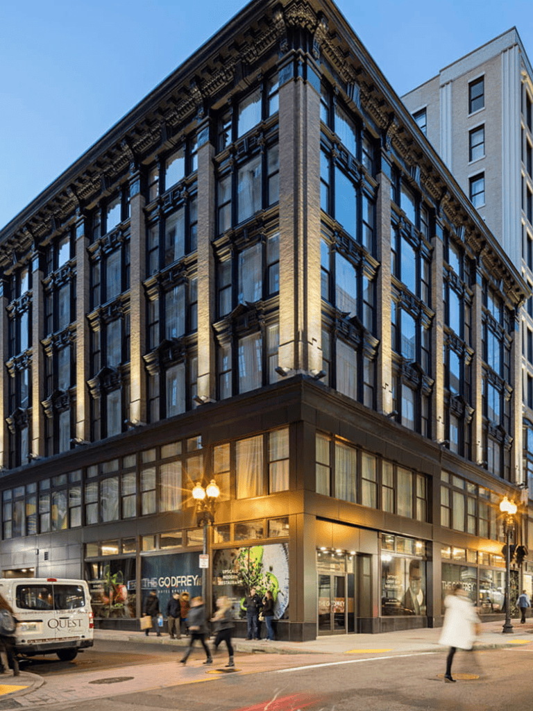 Historic downtown city building with retail stores and busy pedestrians.