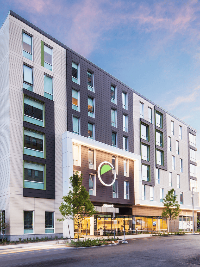 Modern multi-story apartment building with contemporary design and large windows.