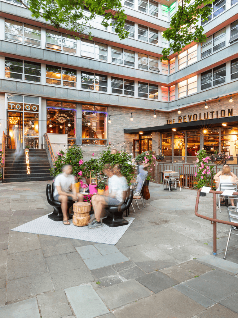 Modern urban restaurant with outdoor seating, vibrant ambiance, and stylish decor, ideal for dining and socializing.