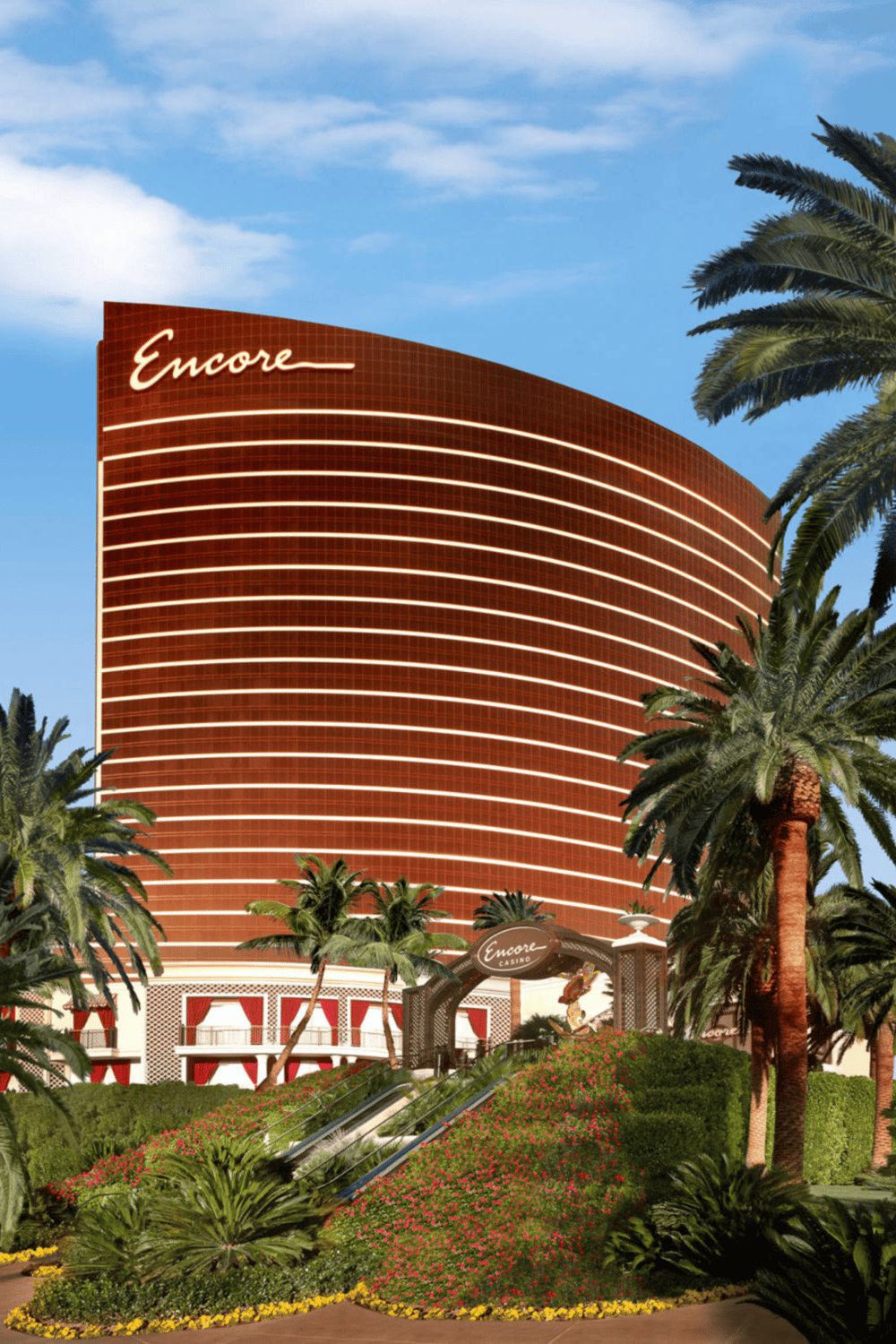 Luxury resort hotel in Las Vegas with palm trees and vibrant landscaping.