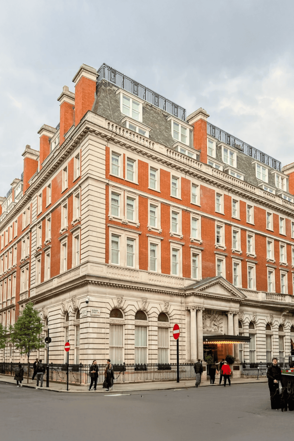 Elegant historic building in London with detailed architecture and a lively street scene.