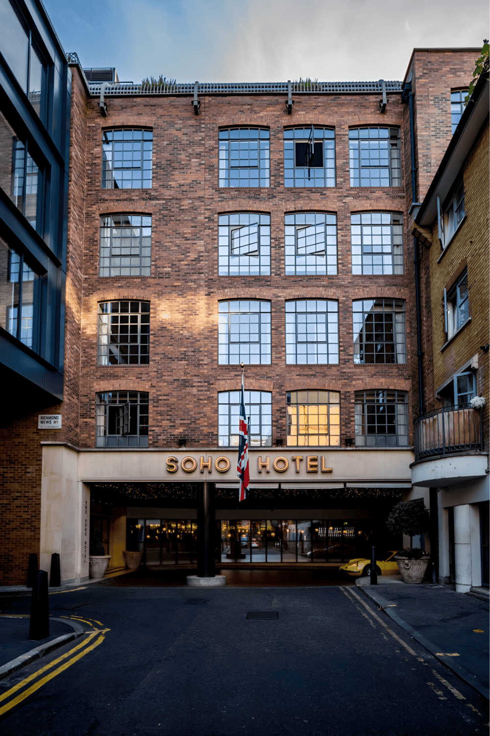 Historic brick Soho Hotel exterior in downtown cityscape.