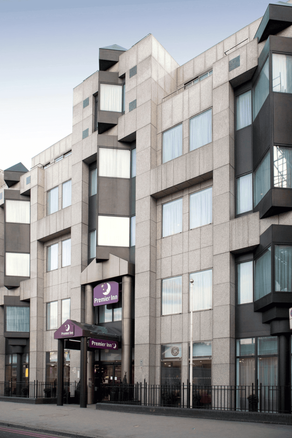 Modern apartment building with Premier Inn hotel entrance for travel accommodations and urban comfort.