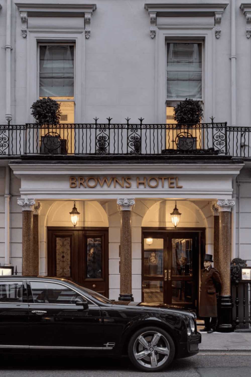 Elegant hotel entrance with classic architecture and luxury car, Browns Hotel in the city center.