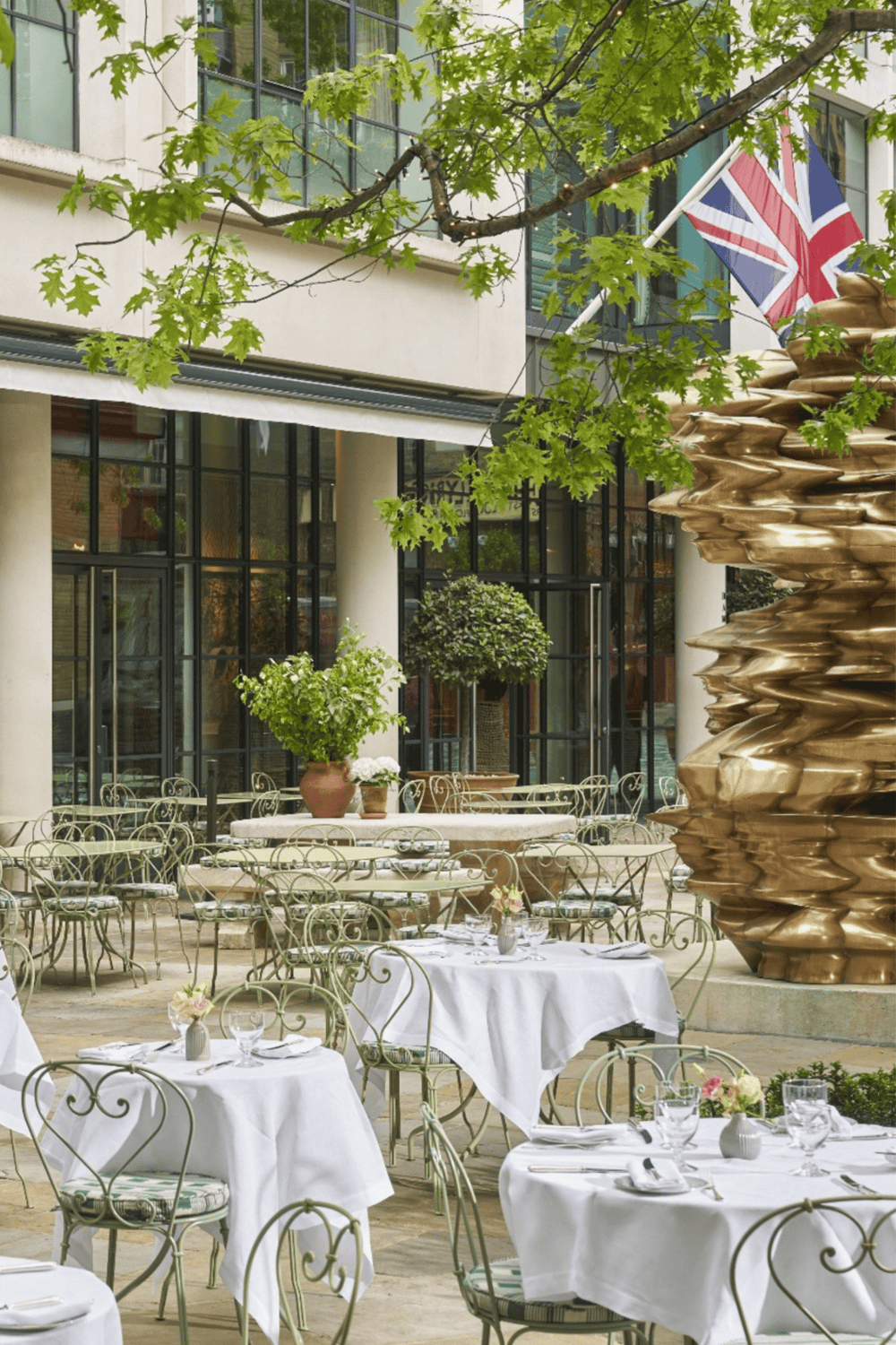 Elegant outdoor dining area with lush greenery and modern architecture.