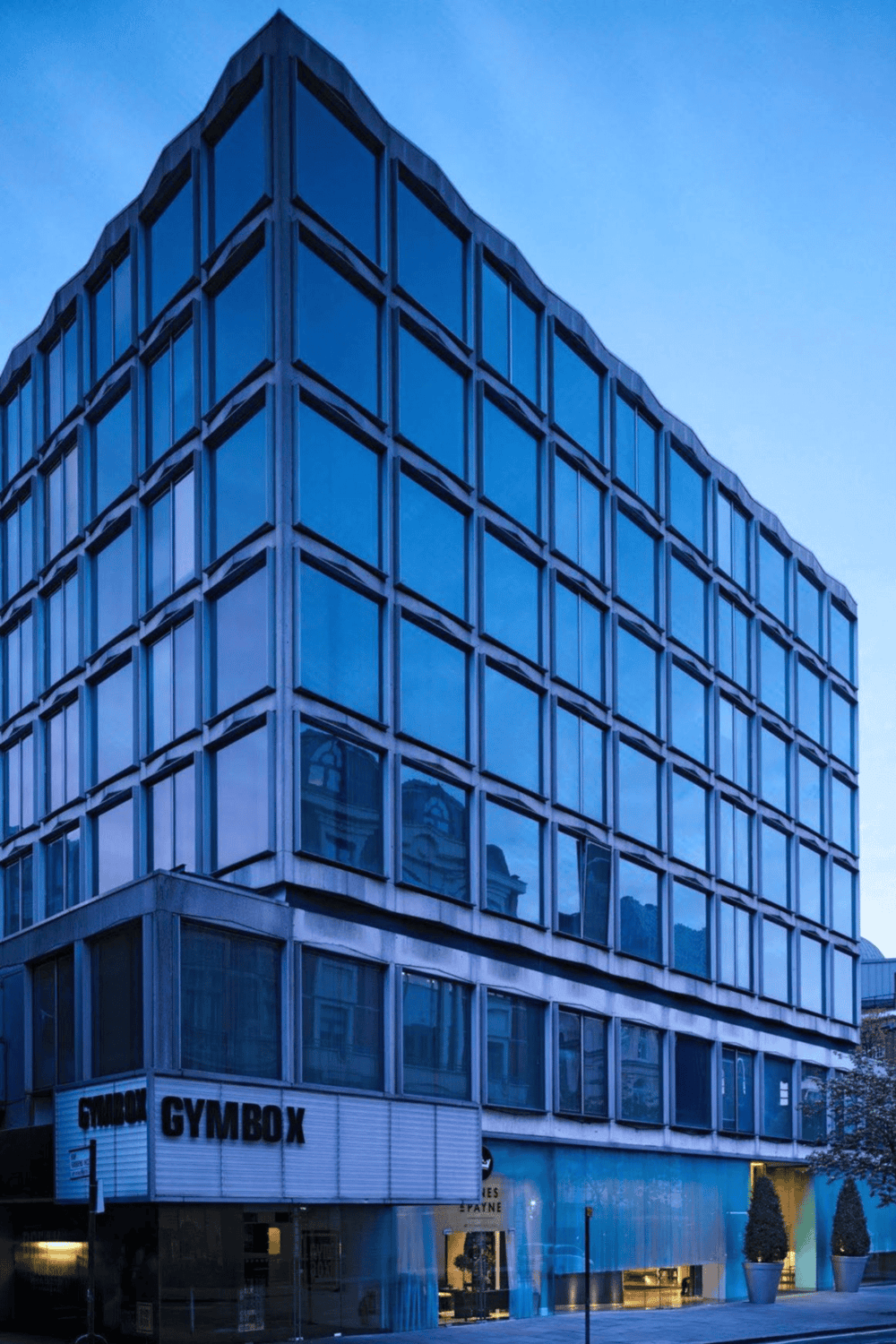 Modern office building with reflective glass windows, downtown cityscape, professional business environment, QuestForDirections.
