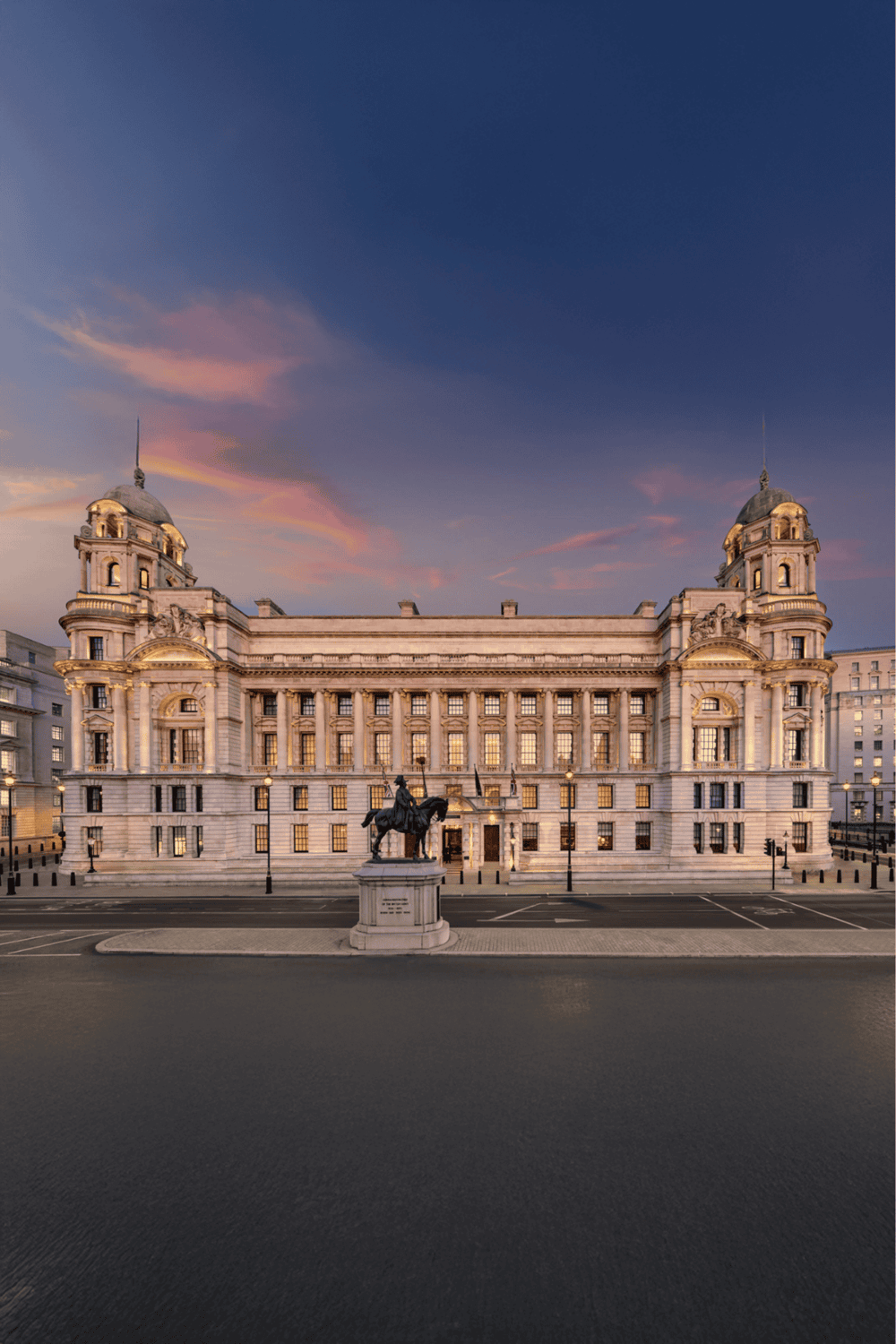 Grand historic government building with statues, known as QuestForDirections Landmark, at sunset.