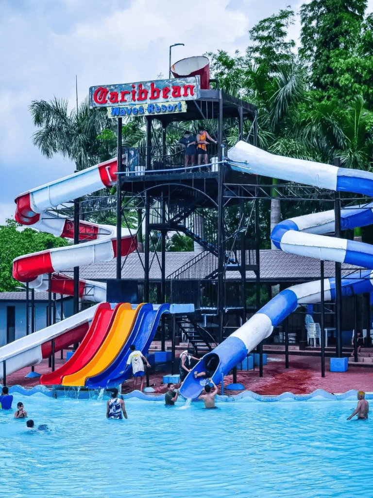 Water park with colorful slides at Caribbean Waves Resort, featuring a large water slide tower and swimming area.