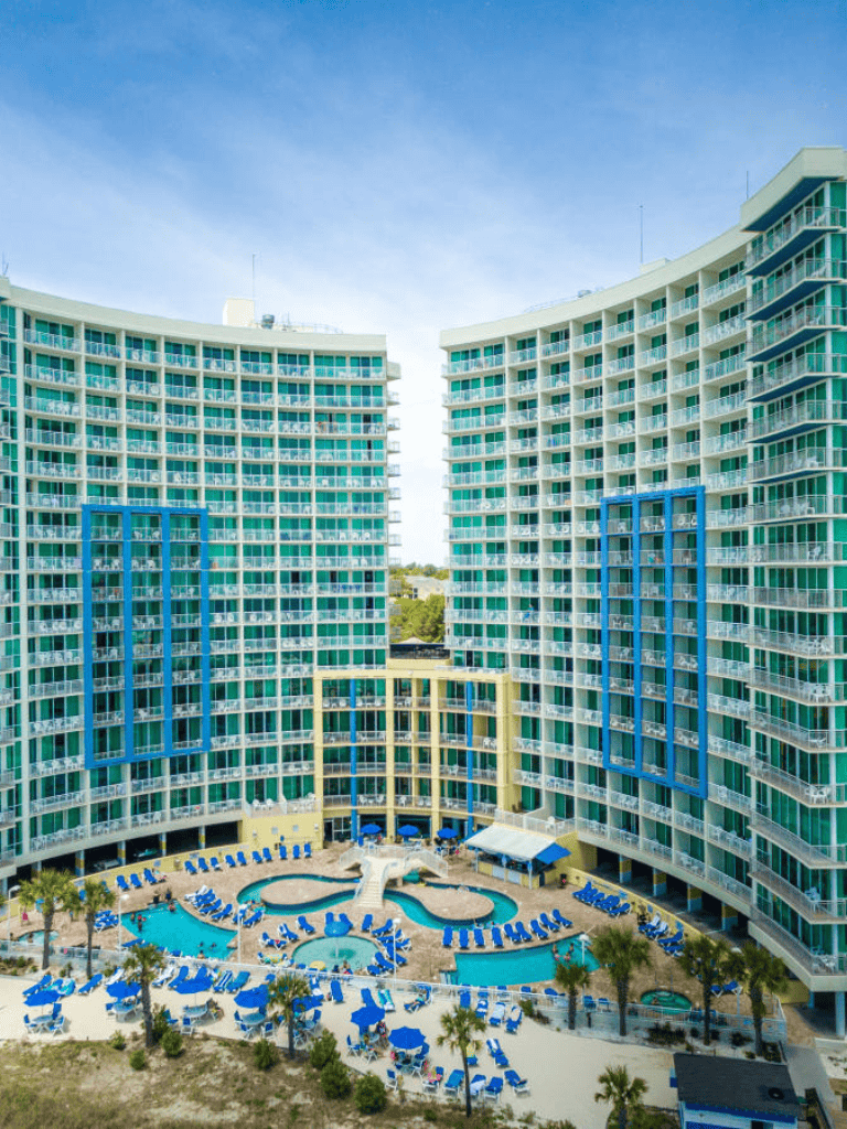 Modern ocean-view hotel with pool and lounge area, ideal for vacation stays in seaside destinations.