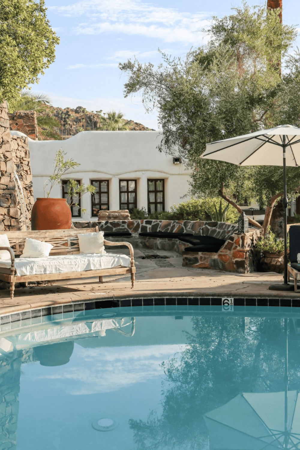 Relaxing outdoor pool area at QuestForDirections resort with seating and lush greenery.