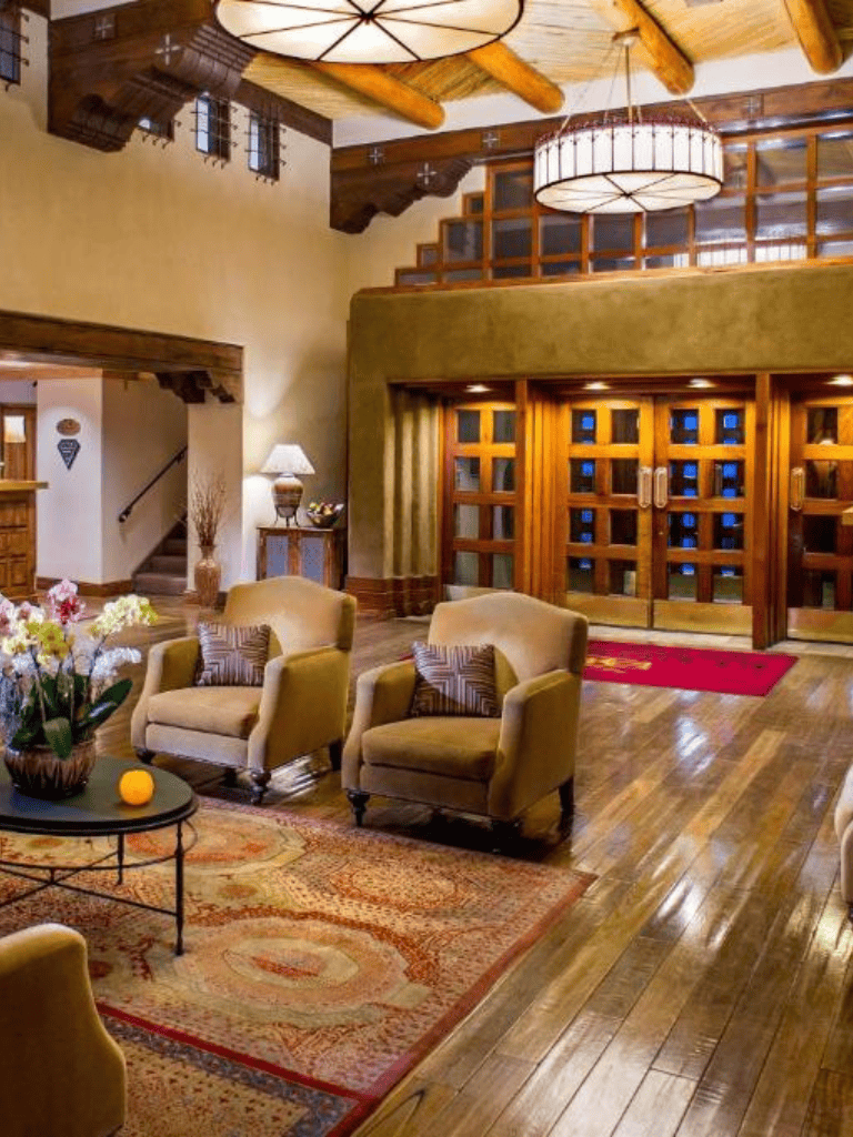 Cozy hotel lobby with wood accents, plush armchairs, and warm lighting for guest comfort.
