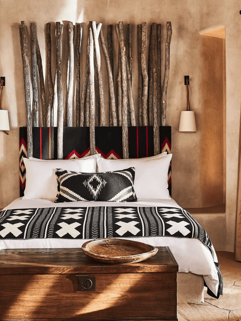Rustic bedroom with wooden log headboard, black and white tribal decor, cozy ambiance, QuestForDirections.