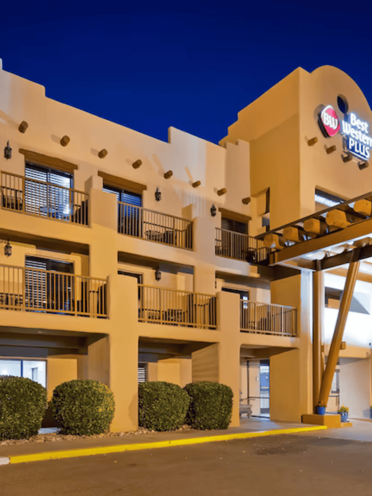 Modern Best Western Plus hotel exterior at night with illuminated signage and balconies.