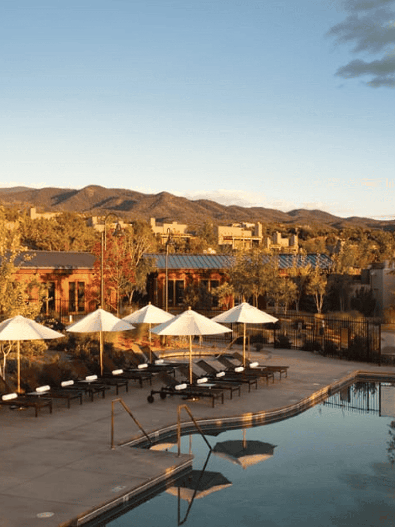 Relaxing resort swimming pool with mountain view and sun umbrellas.