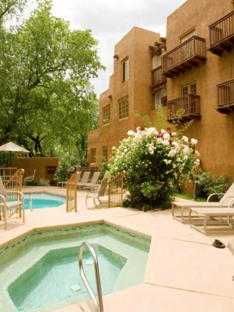 Relaxing hotel hot tub with poolside lounge chairs and lush greenery, perfect for a restful getaway.