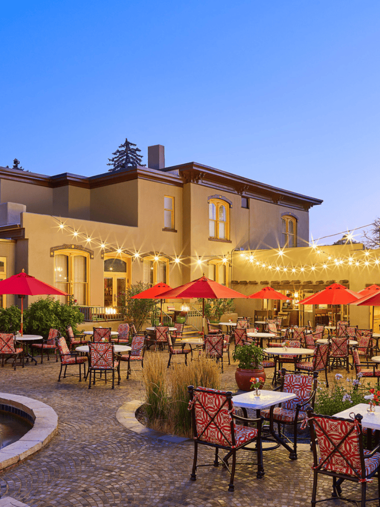 Outdoor dining area at QuestForDirections restaurant, featuring string lights, umbrellas, and cozy seating.