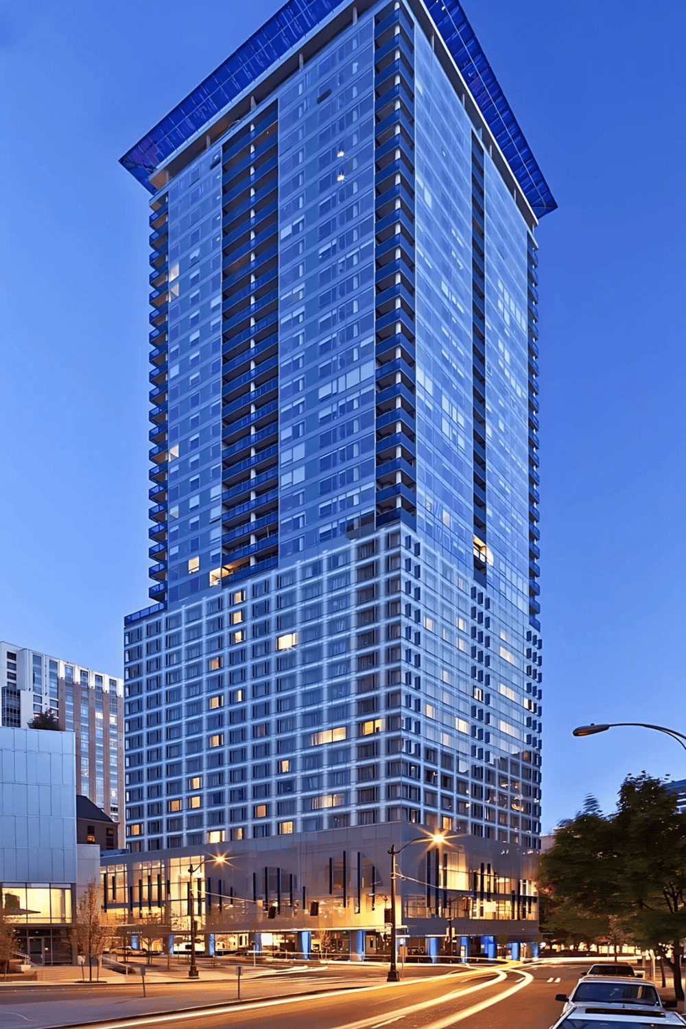 Luxury modern skyscraper in downtown cityscape at dusk.