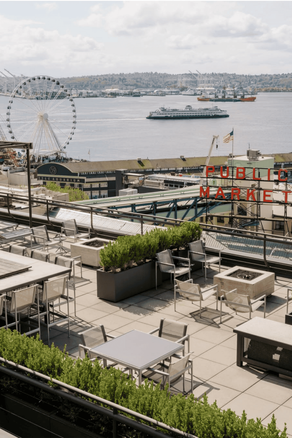 Vibrant Seattle waterfront rooftop with city views, ferris wheel, cruise ships, and public market ambiance.