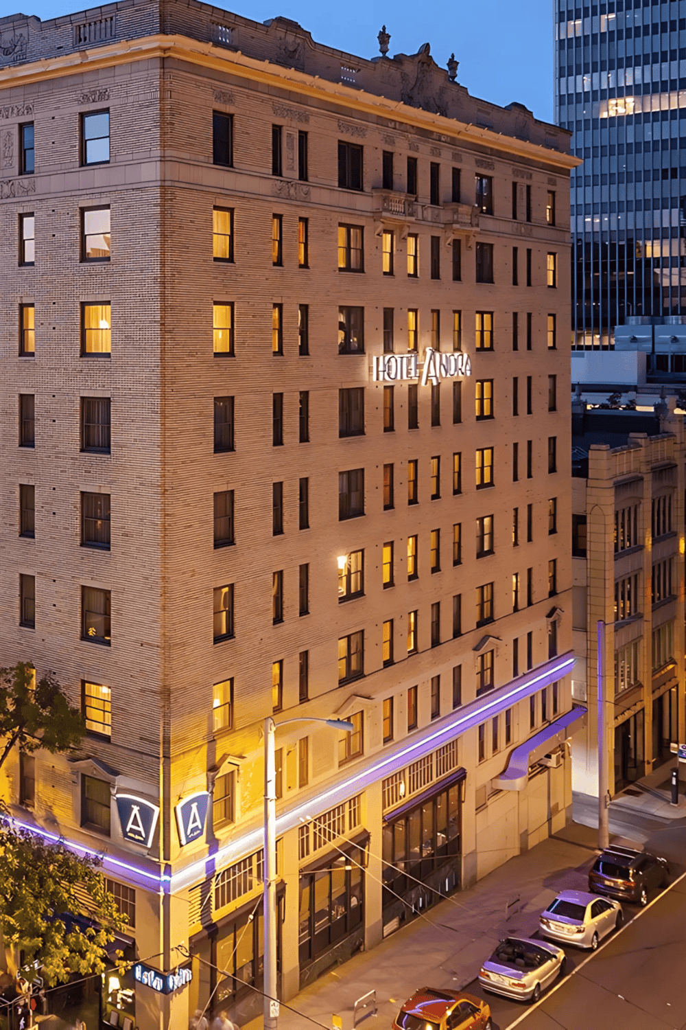 Luxurious hotel building with illuminated signage during evening cityscape.