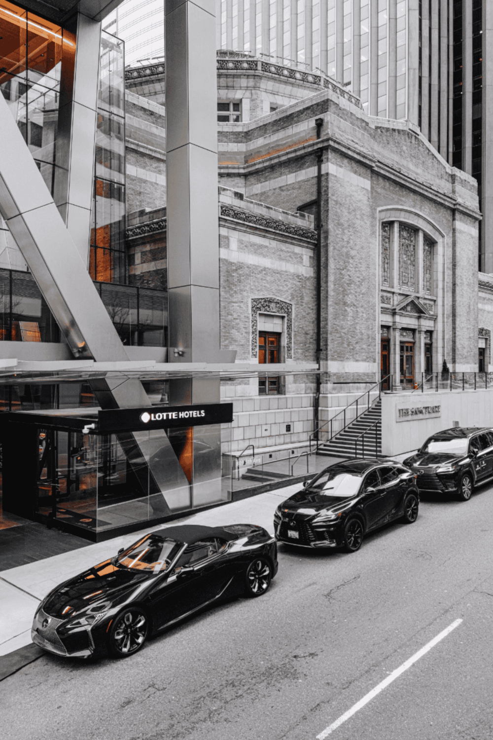 Luxury hotel exterior with modern architecture and high-end cars in downtown city.