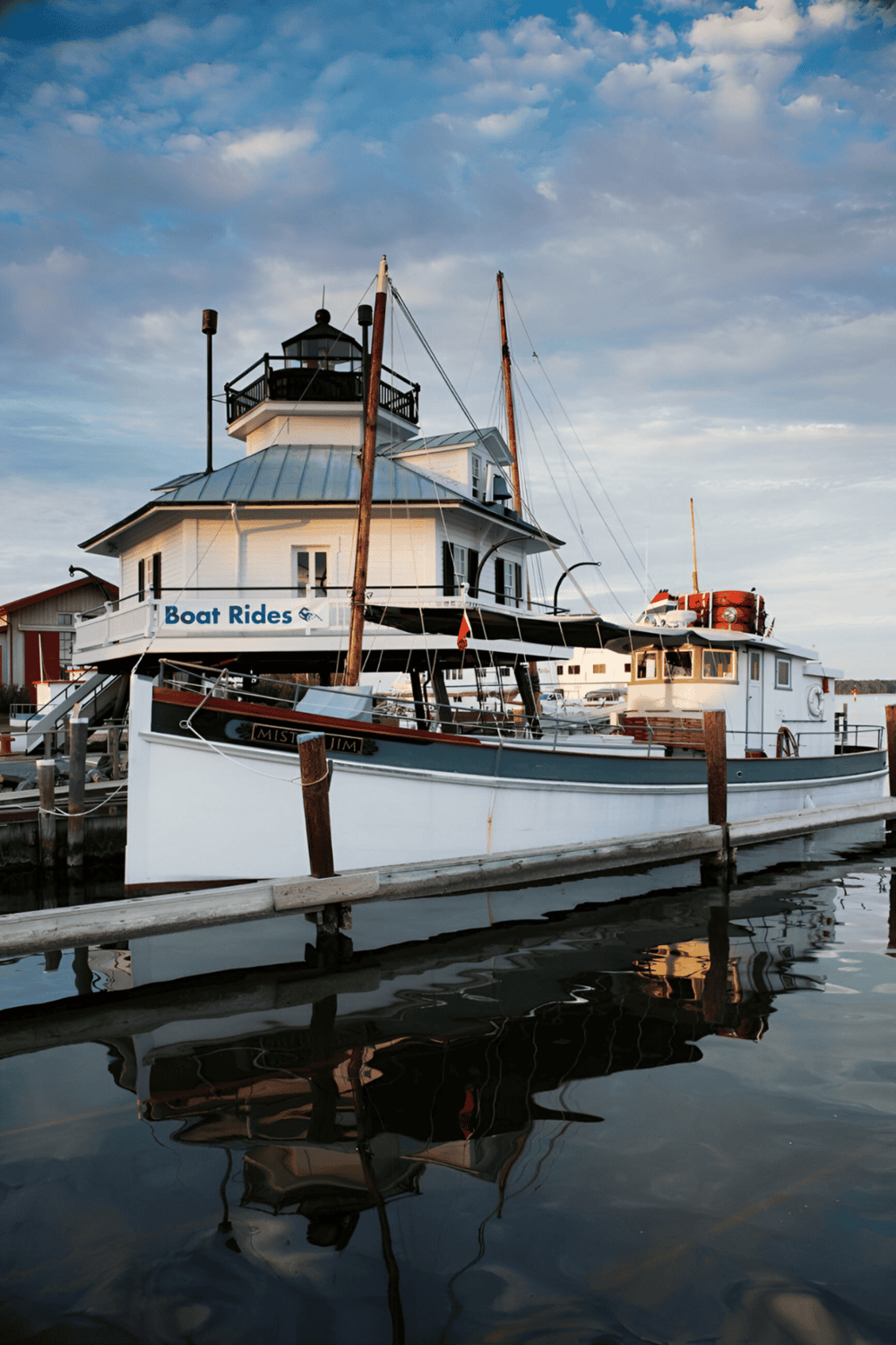 Boat rental at waterfront marina with lighthouse-themed building, offering scenic boat rides and tours.